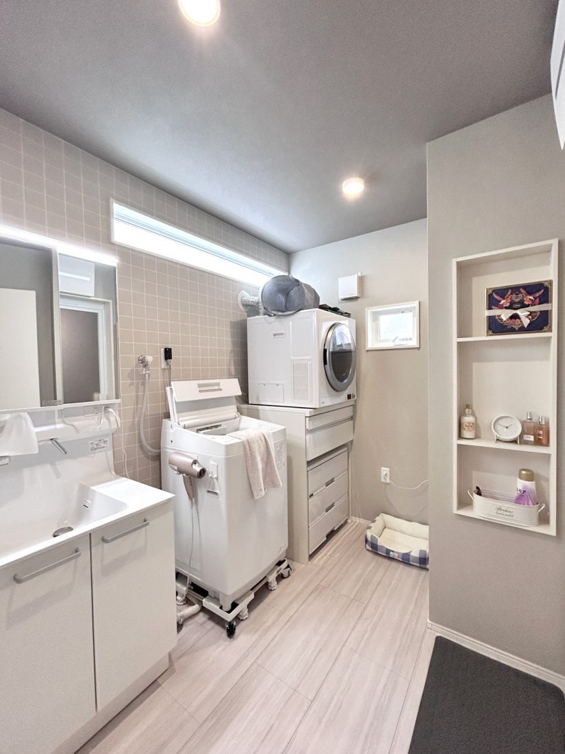 洗面脱衣室には、乾燥スピードと仕上がりに非常に定評のあるガス衣類乾燥機「乾太くん」が。壁面収納は、魅せる収納にも、お風呂から出てすぐ使いたい物の置き場所にも使えます。