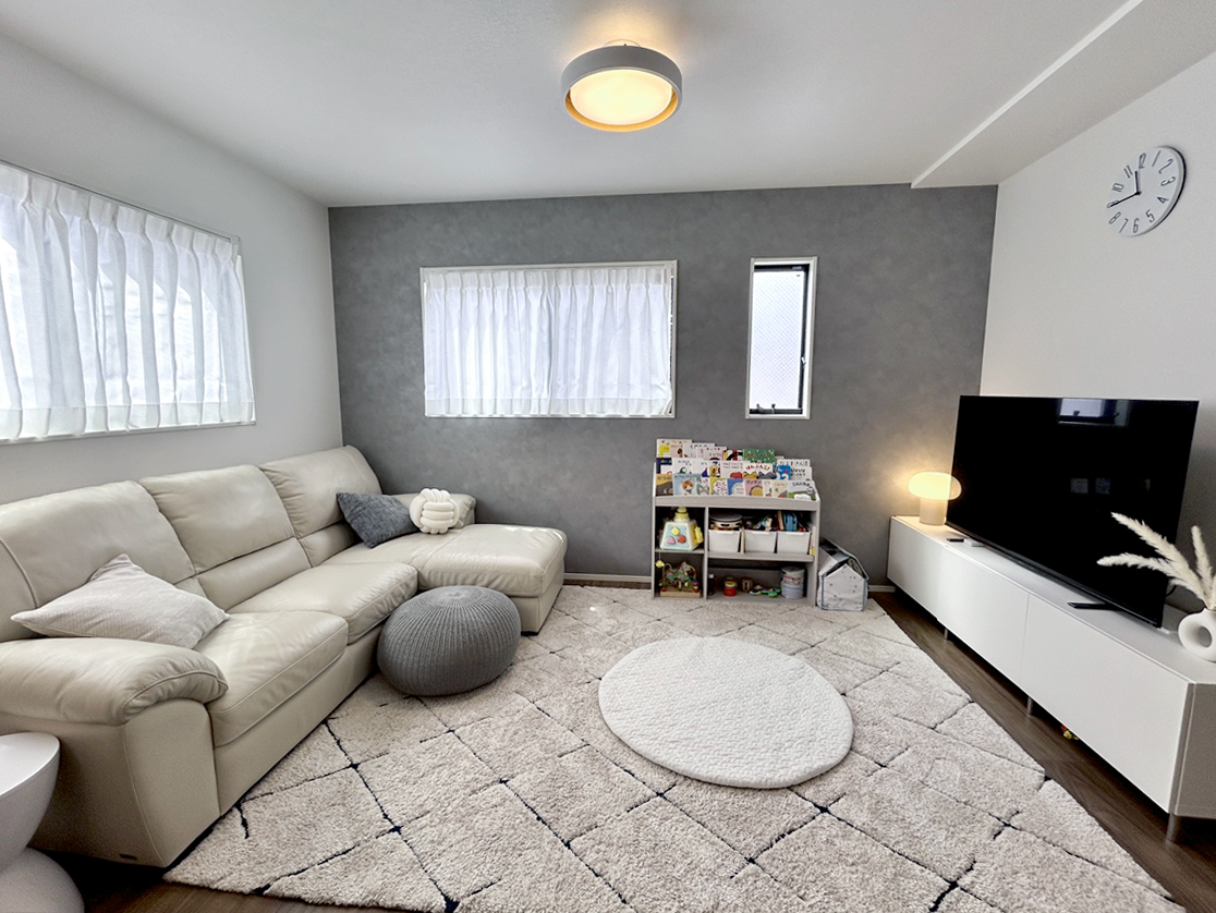 シックにまとめられたリビング。グレーのアクセントクロスがインテリアに美しく調和しています。